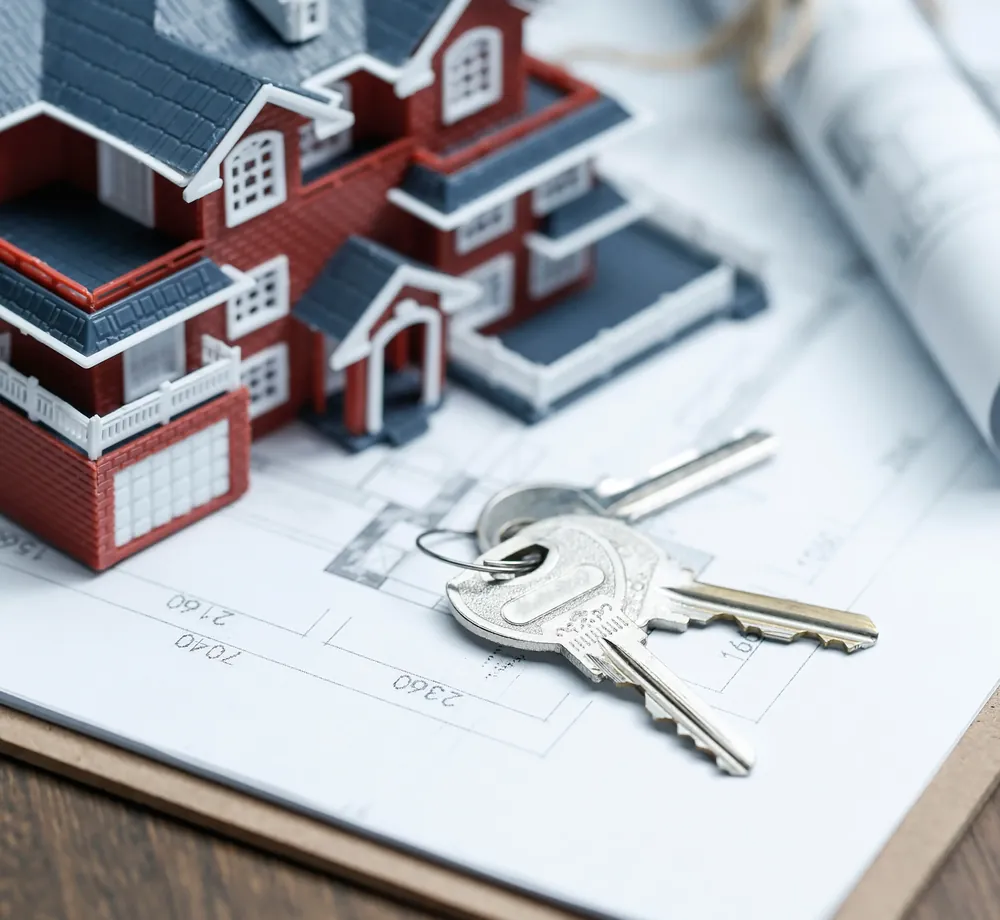 Maquete de casa e chaves sobre a planta, financiamento de imóvel com a FR Prime