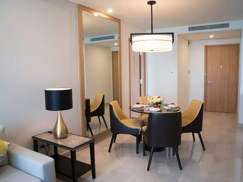 Sala de jantar de um apartamento decorado, com mesa redonda e cadeiras amarelas