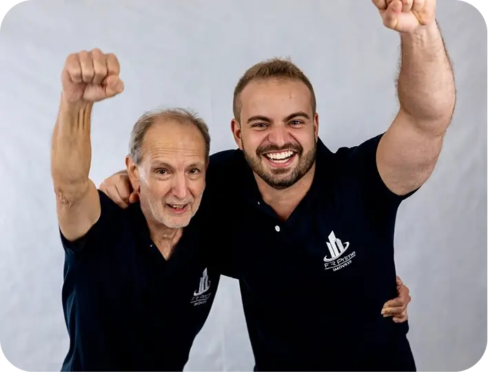 Flávio Ribeiro comemorando de punho erguido ao lado de um senhor, os dois com a camisa da FR Prime