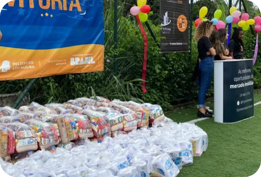 Cestas básicas do Projeto 1C5C arrumadas no campo do projeto Passaporte para a Vitória, ao lado do estande da FR Prime